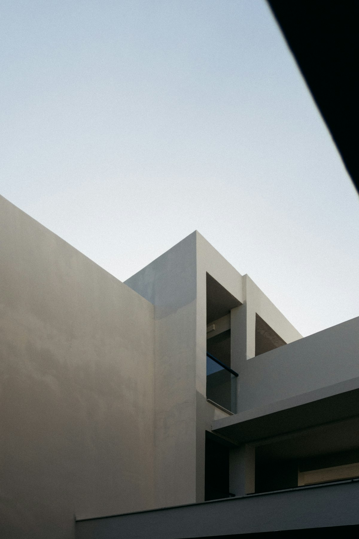 Minimal rendered house forms against an evening sky