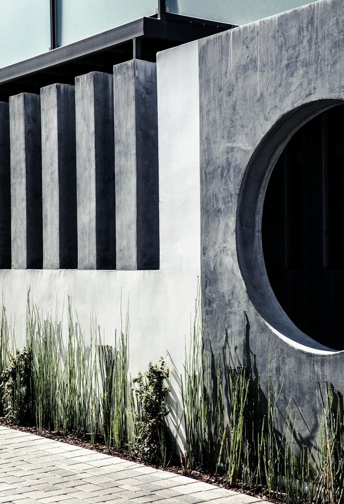 Fluted concrete fence with circular window opening