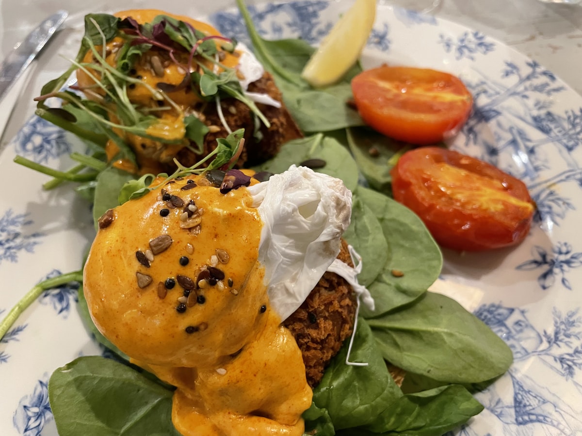 Poached eggs with hollandaise, spinach and roast tomatoes