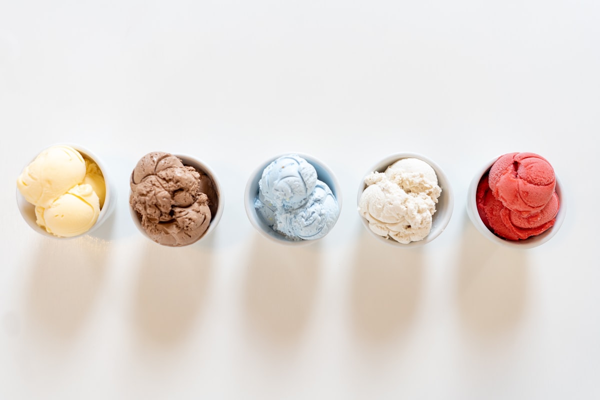 Five colourful cups of gelato lined up in a row